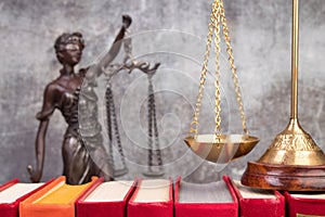 Law concept - Open law book, scales, Themis statue on table in a courtroom or law enforcement office