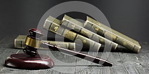 Law concept - Open law book with a wooden judges gavel on table in a courtroom or law enforcement office  on