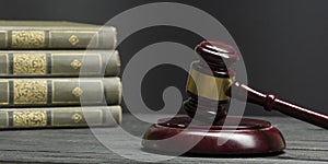 Law concept - Open law book with a wooden judges gavel on table in a courtroom or law enforcement office  on