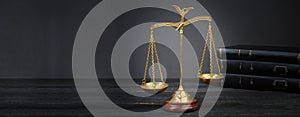 Scales and books on jurisprudence on a wooden background. Legal and law concept. Banner