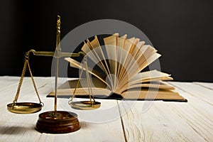 Law concept - Open law book with a wooden judges gavel on table in a courtroom or law enforcement office isolated on white
