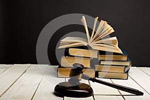 Law concept - Open law book with a wooden judges gavel on table in a courtroom or law enforcement office isolated on white