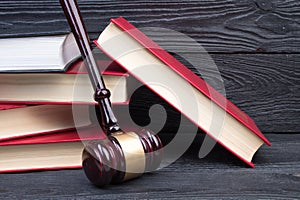 Law concept - Open law book with a wooden judges gavel on table in a courtroom or law enforcement office isolated on white