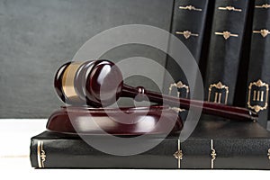 Law concept - Open law book with a wooden judges gavel on table in a courtroom or law enforcement office isolated on white table.