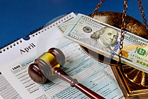 Law concept scales of justice criminal liability for non-payment of taxes of one hundred dollars bill form 1040 on U.S. Individual