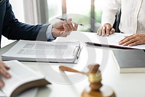 Law concept The solicitor, the man in blue suit, giving his pen to his aider for having her sign on the official document