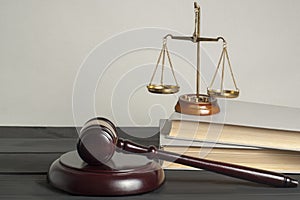 Law concept. Wooden judge gavel with law books ,scales of justice on table in a courtroom or enforcement office.