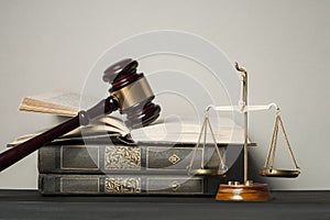 Law concept. Wooden judge gavel with law books ,scales of justice on table in a courtroom or enforcement office.