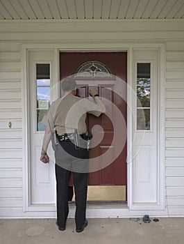 Law enforcement officer knocking on a door