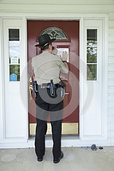 Law enforcement officer posting an eviction notice. photo
