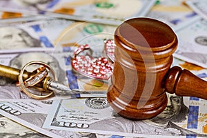 Law family concept judge's gavel on american dollars with wedding rings