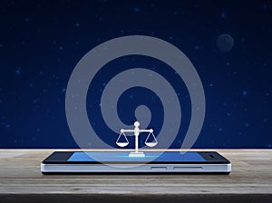 Law flat icon on modern smart mobile phone screen on wooden table over fantasy night sky and moon, Business legal service online