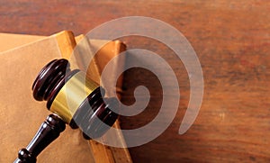 Judge gavel on law books, wooden desk, top view