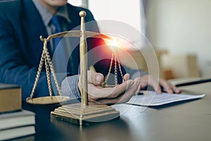 Law and Justice Lawyer working with documents and laptop, hammer, scale at wooden table in office Close-up