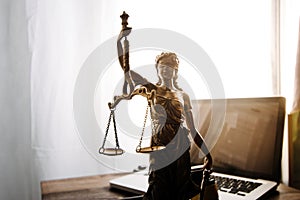 law legal technology concept. judge gavel on computer with scales of justice on desk of lawyer