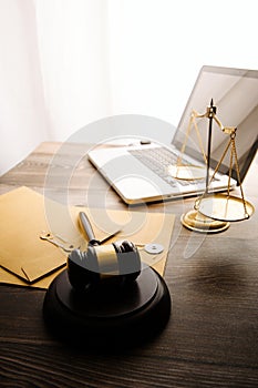 law legal technology concept. judge gavel on computer with scales of justice on desk of lawyer