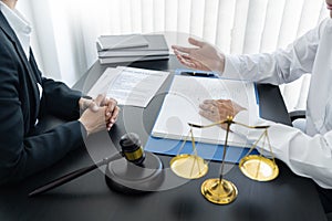 Law,libra scale and hammer on the table, 2 lawyers are discussing about terms and condition, law matters determination