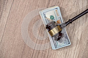 Law mallet with us dollar on wooden surface