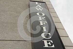 law office sign in white capital letter on black background on side of building-