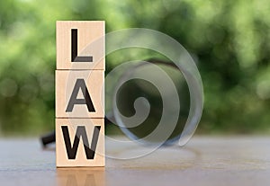 LAW Word On Wooden Blocks on table with magnifier on green background. Law and Justice, Legality concep