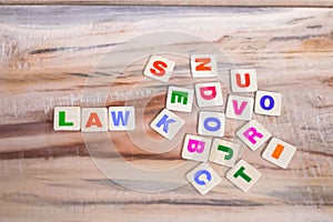 LAW WRITTEN WITH BLOCK LETTERS ON WOODEN TABLE