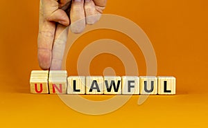 Lawful or unlawful symbol. Businessman turns wooden cubes and changes the word unlawful to lawful. Beautiful orange table, orange