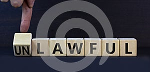 Lawful or unlawful symbol. Turned wooden cubes and changed the concept word Unlawful to Lawful. Beautiful grey table grey