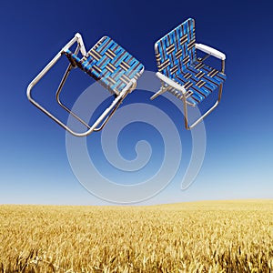 Lawn chairs over wheat field.