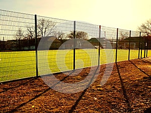 Lawn field for playing minifootball behind the fence mesh