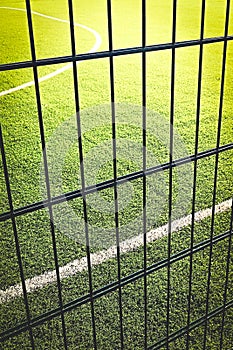 Lawn field for playing minifootball behind the fence mesh