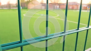 lawn field for playing minifootball behind the green fence mesh