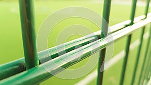 Lawn field for playing minifootball behind the green fence mesh closeup