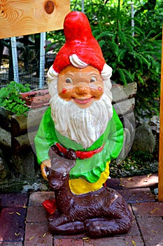Lawn gnome. Nice flowers in the garden in midsummer, in a sunny day.