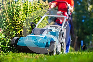 Lawn mover on green grass in modern garden or backyard. Machine for cutting lawns. Gardening care tools and equipment