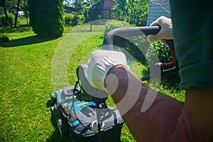 Lawn mover on green grass in modern garden or backyard. Machine for cutting lawns. Gardening care tools and equipment