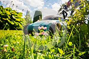 Lawn mover on green grass in modern garden or backyard. Machine for cutting lawns. Gardening care tools and equipment