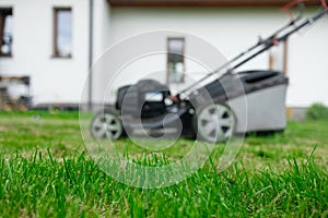 Lawn mover on green grass in modern garden. Machine for cutting lawns.