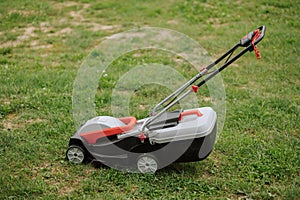 Lawn mover on green grass in modern garden. Machine for cutting lawns.