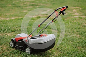 Lawn mover on green grass in modern garden. Machine for cutting lawns.