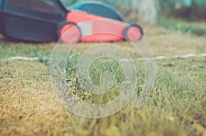 Lawn mower is cleaned from a grass/lawn mower is cleaned from a grass. Selective focus. Toned