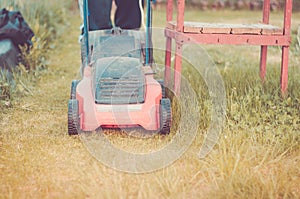 Lawn mower cuts a lawn/red lawn mower cuts a lawn. Toned