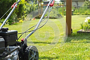 Lawn mower cutting grass in the garden. Gardening. photo