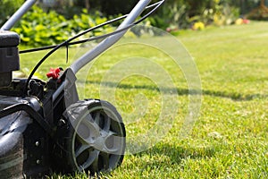 Lawn mower cutting grass in the garden. Gardening photo