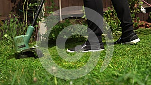 Lawn mower cutting grass. Small Green grass cuttings fly out of lawnmower pushed around by landscaper. Close Up Gardener