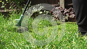 Lawn mower cutting grass. Small Green grass cuttings fly out of lawnmower pushed around by landscaper. Close Up Gardener