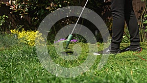 Lawn mower cutting grass. Small Green grass cuttings fly out of lawnmower pushed around by landscaper. Close Up Gardener