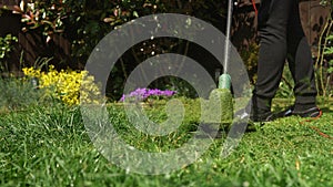 Lawn mower cutting grass. Small Green grass cuttings fly out of lawnmower pushed around by landscaper. Close Up Gardener