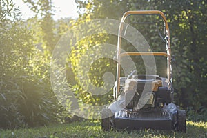 Lawn mower cutting green grass in backyard