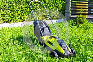 Lawn mower before cutting green grass in backyard