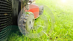 Lawn mower cutting green grass low angle shot with selective focus